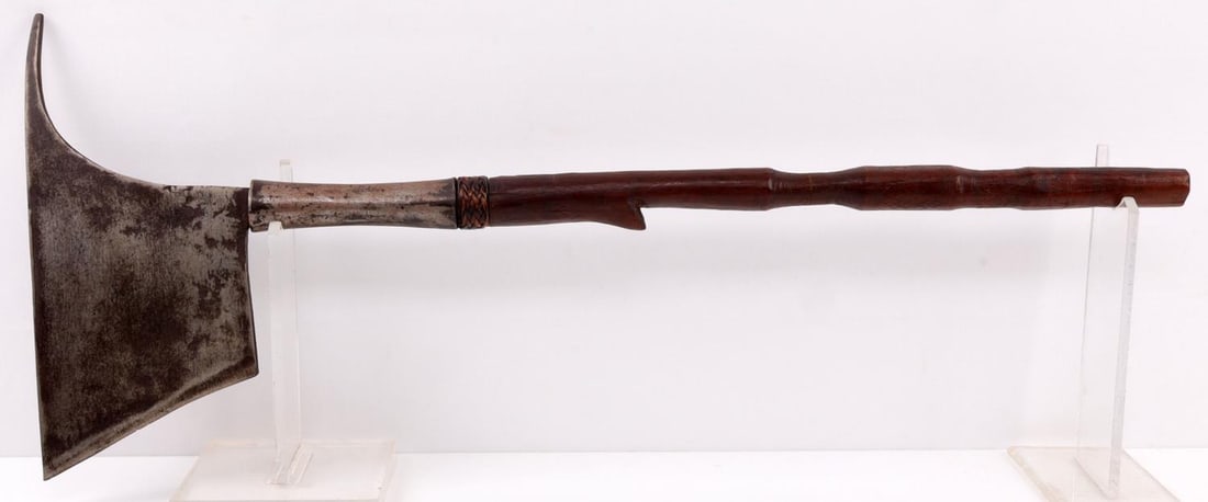 TRIBAL PHILIPPINE KALINGA HEADHUNTER AXE: A headhunter's axe from the Kalinga tribe in the Philippines. The head of the axe is a solid, hand-forged piece of iron. The handle is carved wood. The handle is decorated with subtle hash marks and w