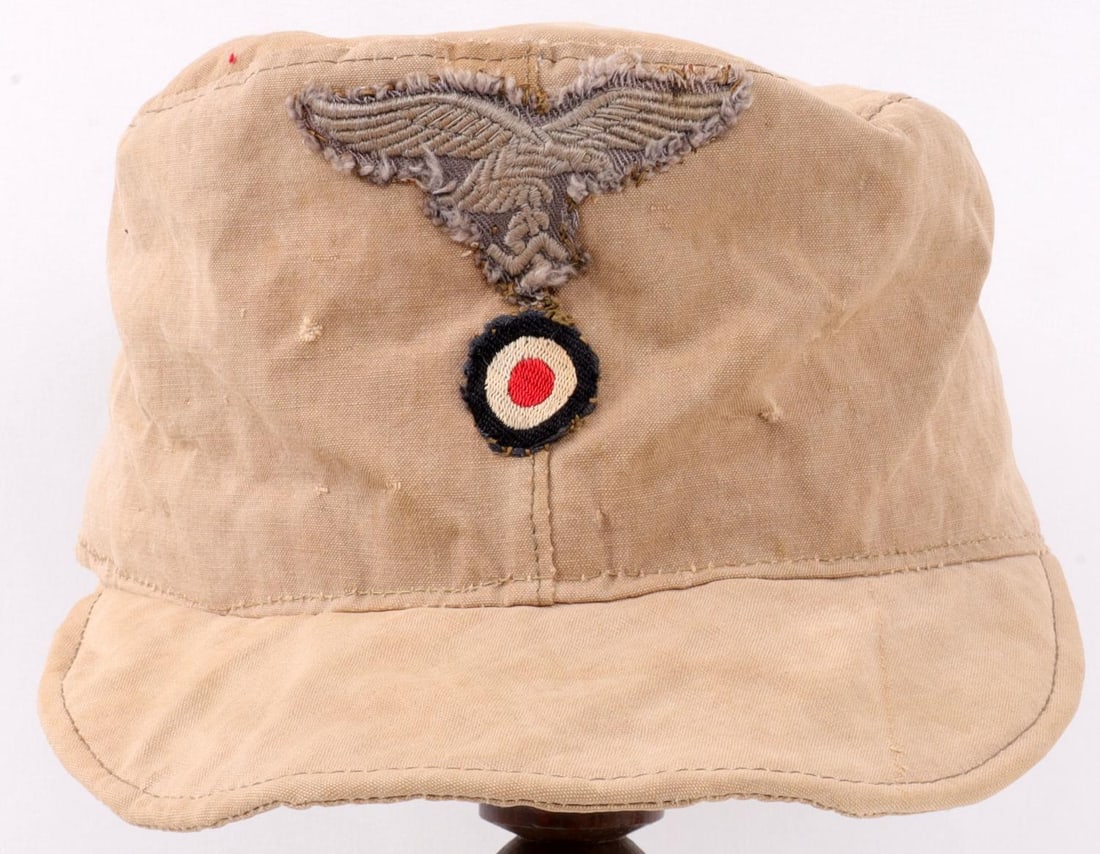 WWII GERMAN LUFTWAFFE M41 AFRIKAKORPS FIELD CAP: Tan cap with Luftwaffe insignia and cockade. Size unknown. Ink stamped red liner. Very good condition. Non-fluorescing.
