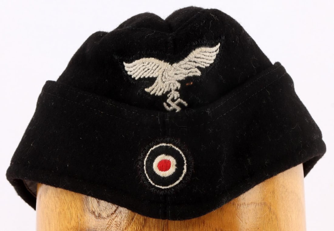WWII GERMAN THIRD LUFTWAFFE OVERSEAS CAP: Black wool cap with Reichsadler patch and cockade. Interior ink stamped 57 RBN/4756/9448. Non-fluorescing. Very good condition. Unauthenticated, sold as is.