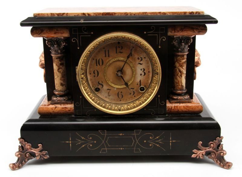 19TH CENTURY SETH THOMAS ADAMANTINE MANTLE CLOCK: A Beautiful mantle clock made with Adamantine veneer in black and marble pattern. The black areas feature Charles Eastlake style decorations. Lion head handles to sides. Metal feet. Key is present. 16