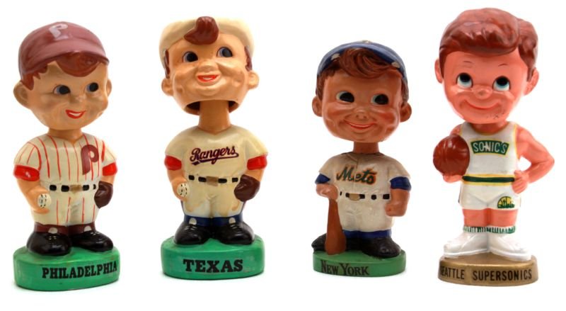 FOUR VINTAGE BOBBLE HEADS 3 BASEBALL 1 BASKETBALL: New York Mets figure 6.5 inches tall, Texas Rangers figure 7.5 inches tall, Philadelphia Phillies figure 7.25 inches tall. One Seattle Supersonics basketball figure 7.5 inches tall. All in very good c