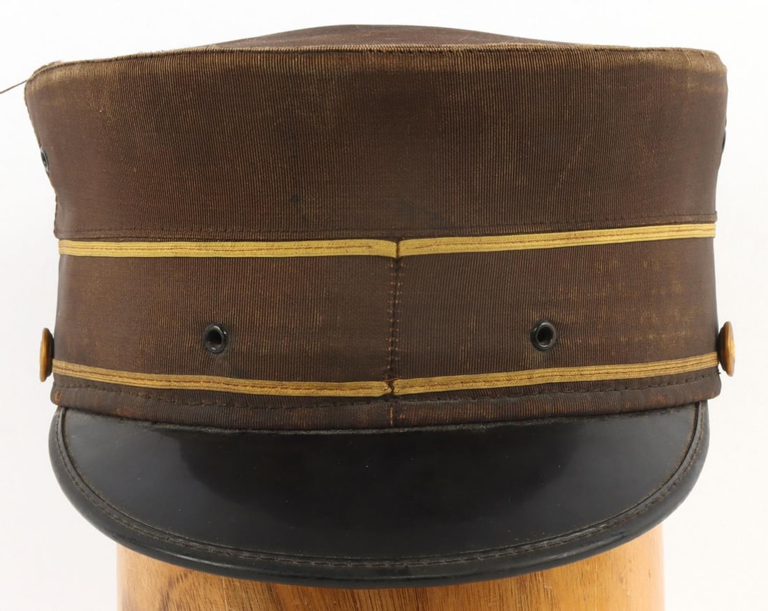 NEW YORK CENTRAL RAILROAD STATION MASTER VISOR CAP: Summer weight pill box cap of the type worn by New York Central Railroad officials. Gabardine cloth exterior, with interior rattan frame and ventilated leather sweatband. Brass buttons with "NYC" in r