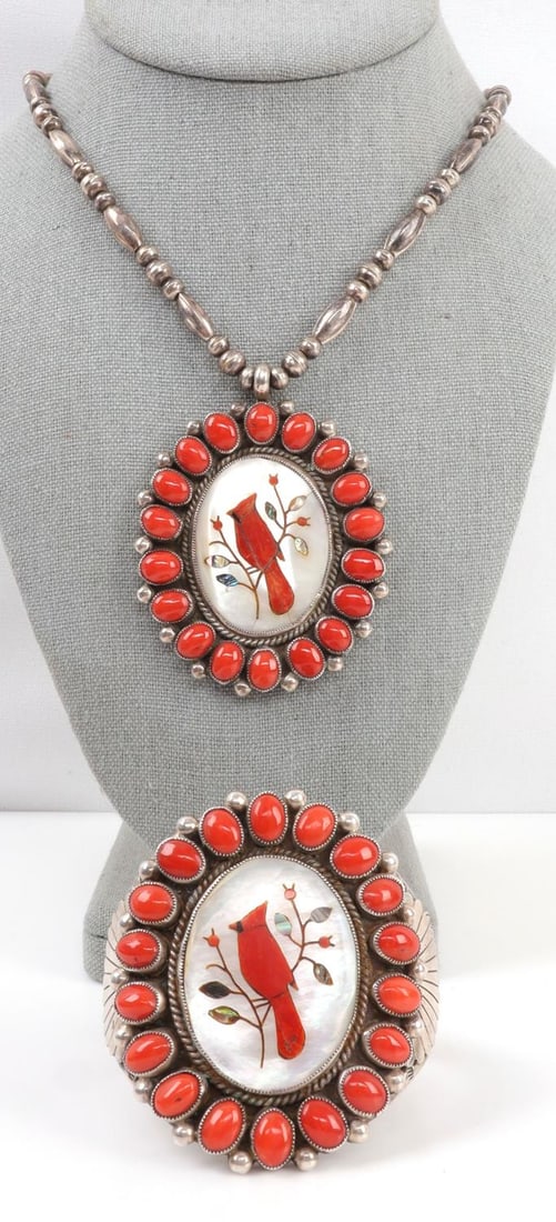 NAVAJO CORAL & SILVER CARDINAL NECKLACE & CUFF: 1) Silver and coral necklace depicting a cardinal on a branch. Cardinal is inlaid on mother of pearl. Silver tested. Weighs 57.2 grams. 27 inches. 2) Silver and coral cuff depicting a cardinal on a br