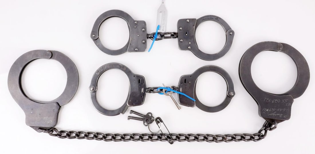 LOT OF 3 MARKED US MADE IRON ANTIQUE HANDCUFFS: Lot of THREE (3). 1) Harvard Lock Company large handcuffs, 25 inches (L). Marked, "O. Burgers US 55-029-421. Key included. 2) American Handcuff Co. Handcuffs small, 9 inches (L). Marked, "O. Burgers U