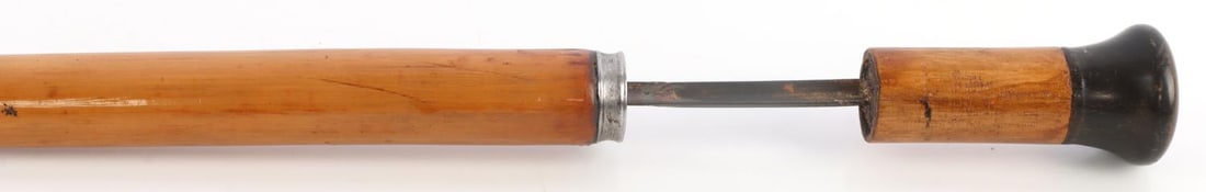 ANTIQUE SWORD CANE WITH CONCEALED TREFOIL BLADE: Antique sword cane with a concealed trefoil blade. Dark brown knob, possibly celluloid, and iron ferrule. 21.75-inch trefoil blade, 32-inch overall cane length. Very good, original condition. This lot