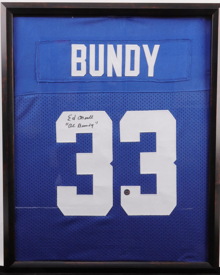 ED ONEILL SIGNED AL BUNDY JERSEY COA INCLUDED: A framed replica of Al Bundy's Polk High School number 33 jersey from Married... With Children. Ed O'Neill has signed the jersey and added an "Al Bundy" in quotations. RCG authentication #A0082. 17 X 