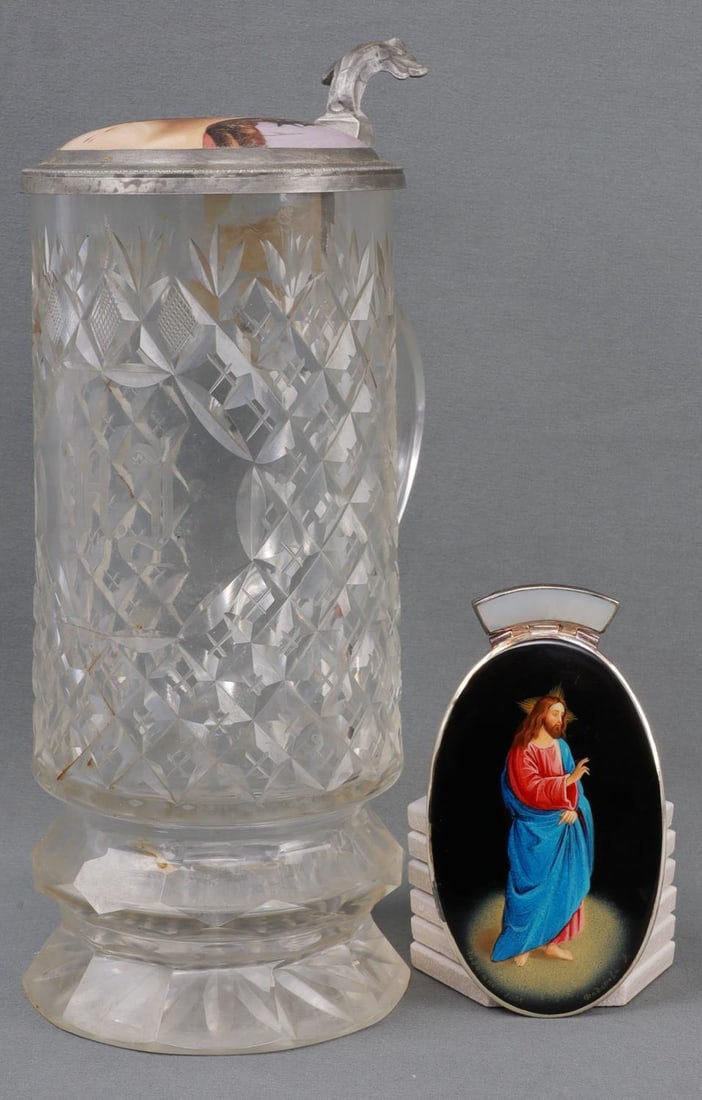 LOT OF 2 HAND PAINTED MEDALLION & JESUS STEIN: Lot of TWO (2). 1) Hand painted Jesus medallion on black with a mother of pearl clasp. Writing in Russian on bottom, dated 2005. 2 X 4 inches. 3) Glass pint with a painting of the crucified face of Ch
