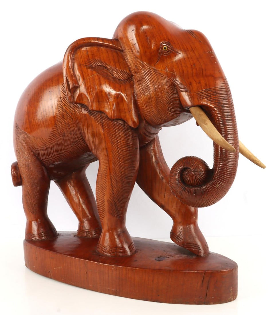 LARGE SOLID WOOD ELEPHANT STATUE ON BASE: Two-piece construction of carved solid wood. Good craftsmanship and nicely detailed with removable wooden tusks. Dimensions: 19 X 17.5 X 7 inches. Statue has seen some action, but in good overall cond