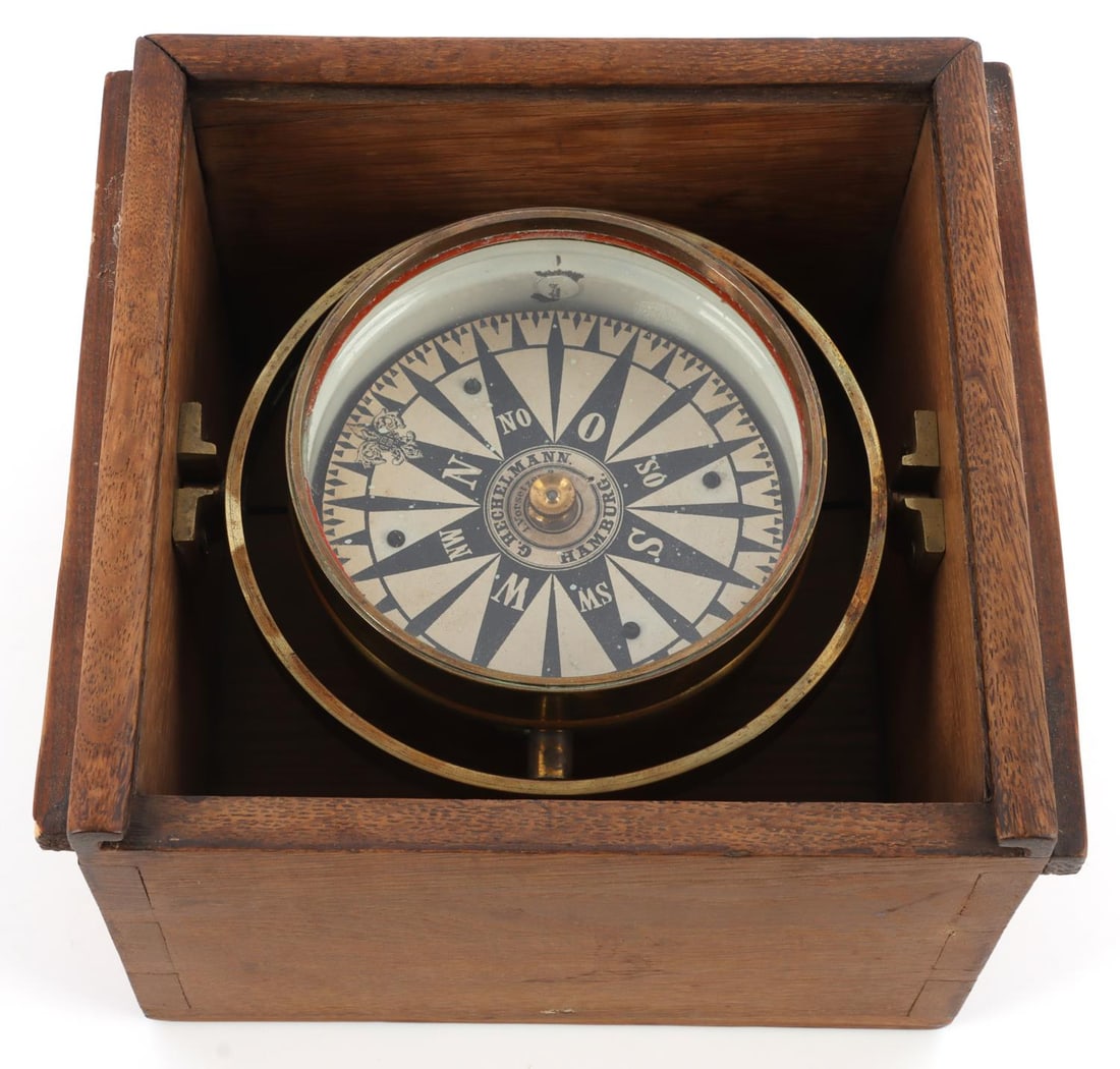 ANTIQUE BRASS SHIPS COMPASS BY G. HECHELMANN: Gimbaled ship's compass in wood and brass. Central compass face has a mark saying 'G. Hechelmann Hamburg.' Diameter of compass face is approximately 4.5 inches, while the wood case is 7.25 X 4.75 X 7.