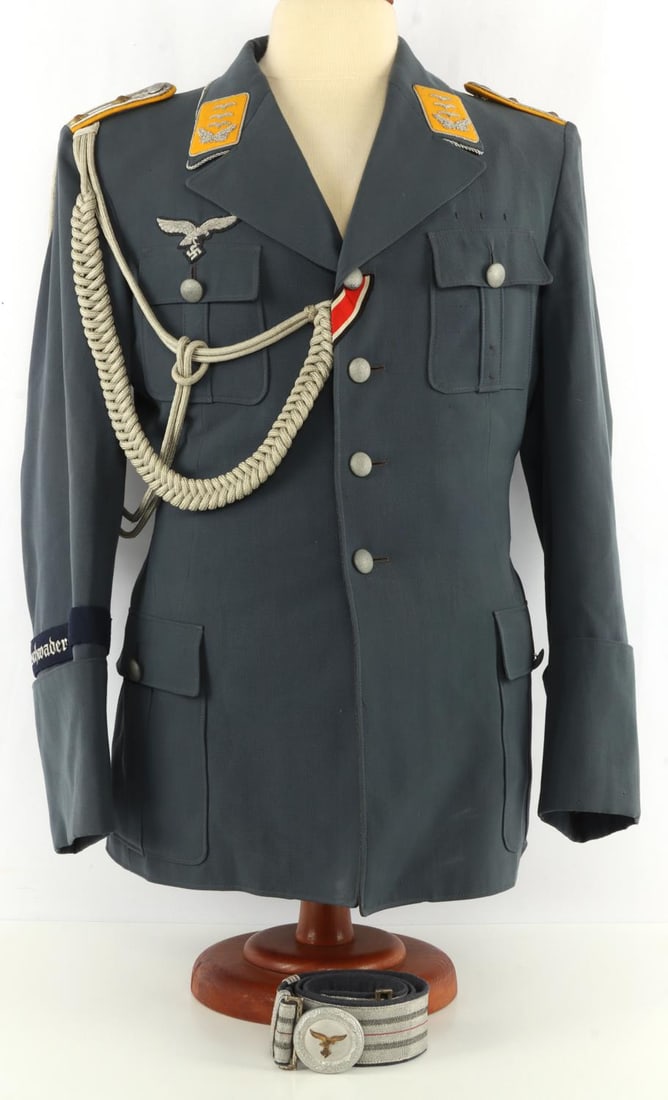WWII GERMAN THIRD REICH LUFTWAFFE HAUPTMAN UNIFORM: A blue Luftwaffe officer's tunic. Hauptman (Captain) rank pips and collar tabs, Geschwader Boelcke cuff title, and Iron Cross button ribbon. Buttons are dimpled metal, marked 'Friedrich Linden Lindens