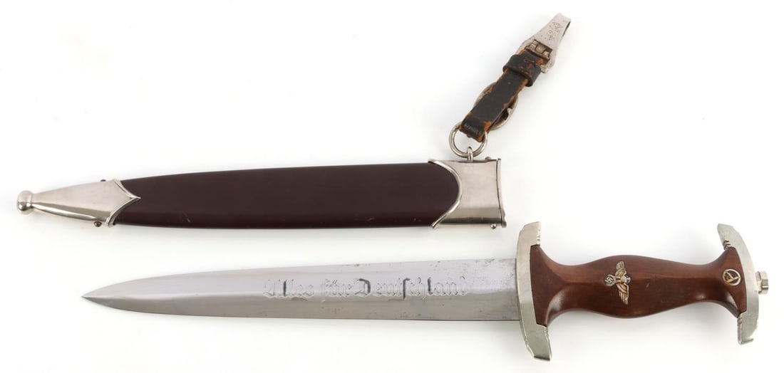 WWII GERMAN THIRD REICH SA DAGGER HACO BERLIN: Steel blade with etched motto and RZM mark. Plated crossguards, Tang does not feature filing. Wood grip with inlaid eagle and SA runes. 8 5/8-inch blade. Housed in standard scabbard. Dagger hanger mar