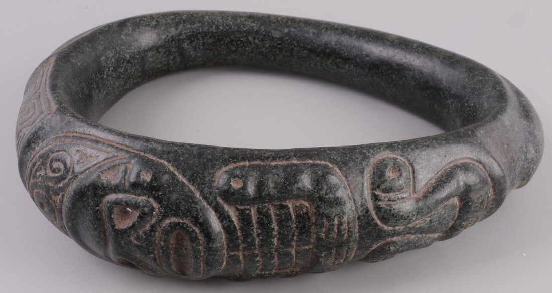 TAINO PRECOLUMBIAN STONE YOKE: Stone game yoke with human figure incised on the front. 9.5 inches across. Very good condition. This lot has a reserve.