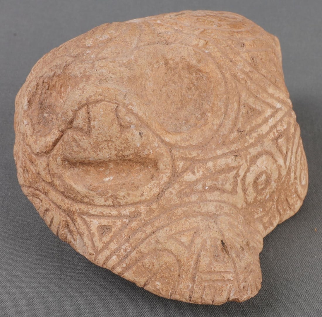 PRECOLUMBIAN TAINO INCISED ANTHROPIC FACE: Pre-Columbian Taino. Anthropic face, fully incised. Possibly an ancestral representation. 3.5 inches. Taino culture. C. 600-1500 AD Greater Antilles. Private European collection.