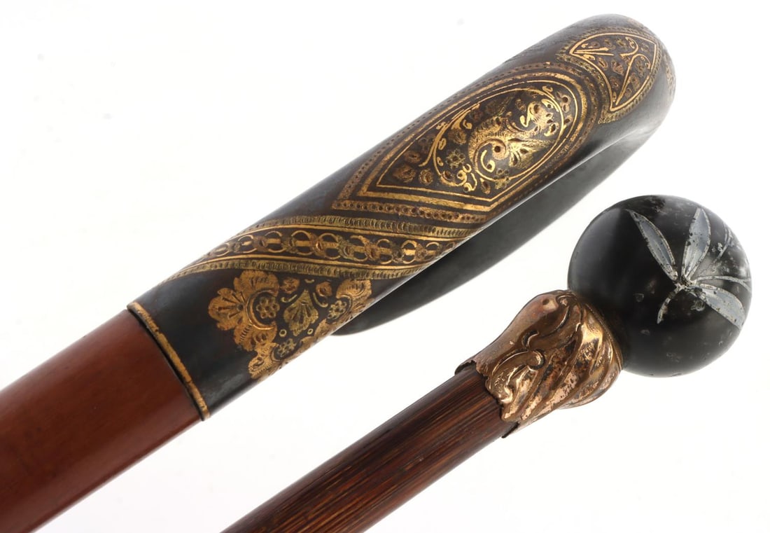 ANTIQUE LADY WALKING STICK CANE LOT OF 2: Lot of 2 Antique Lady's Walking Stick Canes. 1) Ball grip with floral motifs, wood shaft, good light feel, measures 35 1/4 inches. 2) Buffalo grip with golden decorative markings, wood shaft, good hea