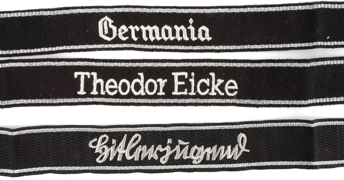 LOT OF 3 WWII GERMAN THIRD REICH CUFF TITLES: Lot of THREE (3). 1) Germania cuff title. Silver metallic thread and rayon. 21.5 inches. 2) Theodor Eicke cuff title. Silver metallic thread and rayon. 18 inches. 3) Hitlerjugend cuff title. Silver me