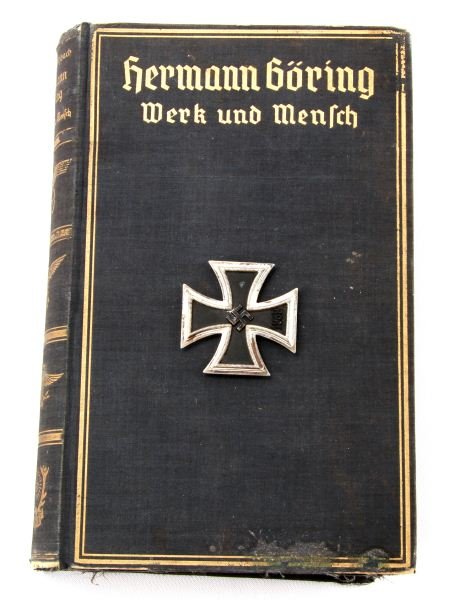 HERMANN GORING WERK UND MENSCH WITH IRON CROSS: Early Goring biography covering the period up to World War II. Navy blue cloth with gilt titles, numerous black and white photos. All text is in German. With a WWII Iron Cross (spurious). Both in good