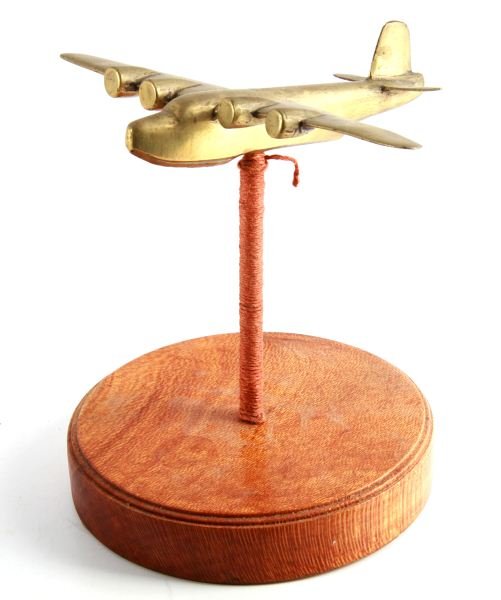 WWII WARTIME BRASS SUNDERLAND ON STAND TRENCH ART: Stand made of wood and stands approximately 9 inches tall, trench are measures 8 inches long with a wingspan of 10.5 inches. Overall in good condition.