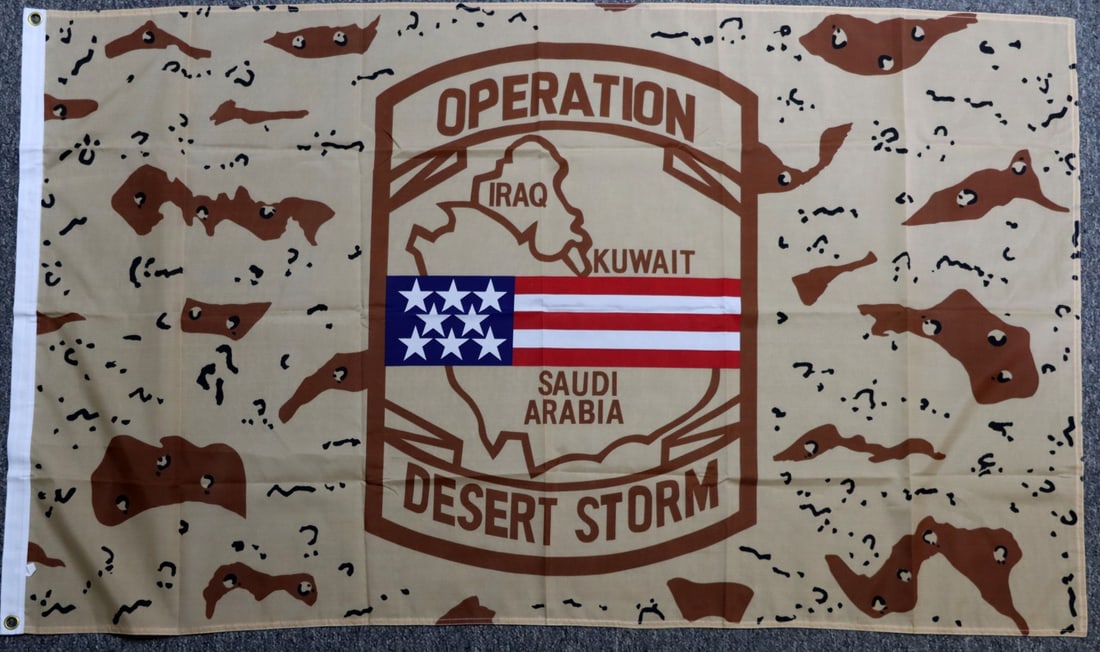 US FLAG FOR OPERATION DESERT STORM: United States campaign flag for Operation Desert Storm. Shows an American flag over Saudi Arabia, Kuwait, and Iraq over desert camo. 59.5 X 35.25. Very good, original condition.