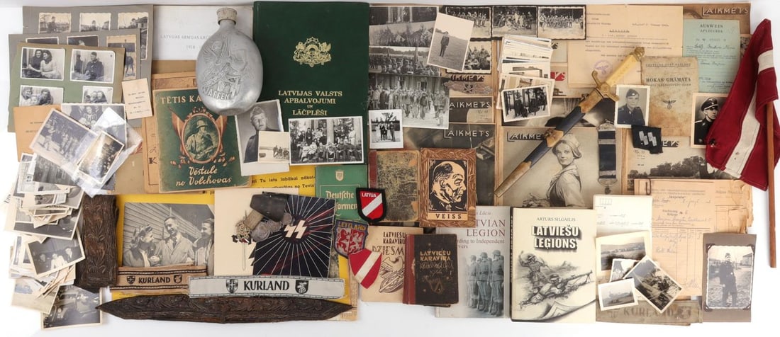 WWII GERMAN THIRD REICH LATVIAN GROUPING: Variety of documents, badges, cuff titles. Rare photographs and coins. Very good condition overall.
