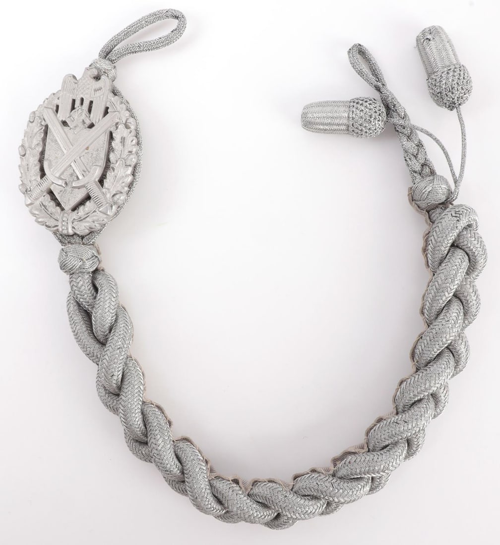 WWII GERMAN WEHRMACHT MARKSMANSHIP AWARD 2 ACORNS: 16-inch silver bullion cord with badge and 2 acorns. Rare reward. Very good condition. This lot has a reserve.