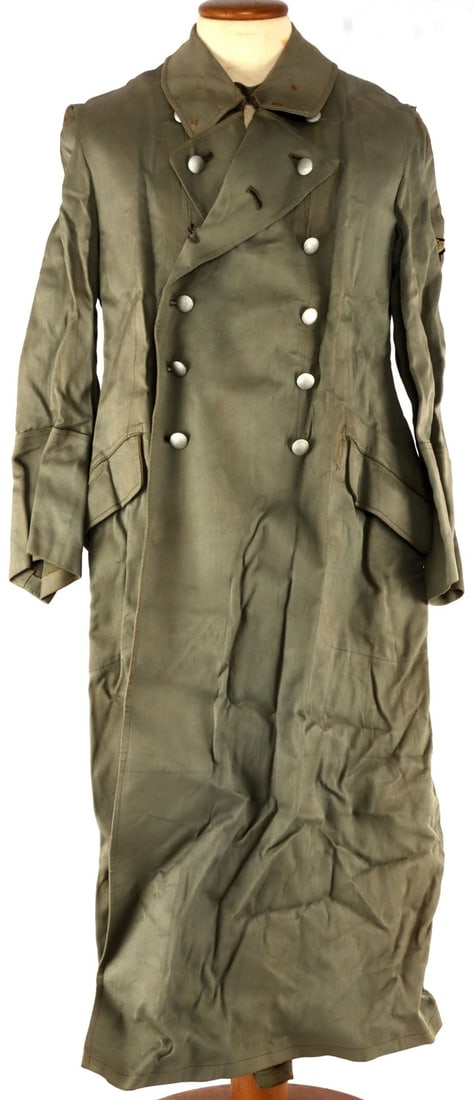 WWII GERMAN REICH WAFFEN SS GHABARDINE OVERCOAT: Field gray overcoat with the Waffen-SS Reichsadler on the sleeve. Sleeves stitched on top post-war, collar has rust stains from previous placement of collar tabs. Interior of jacket has been taped in 