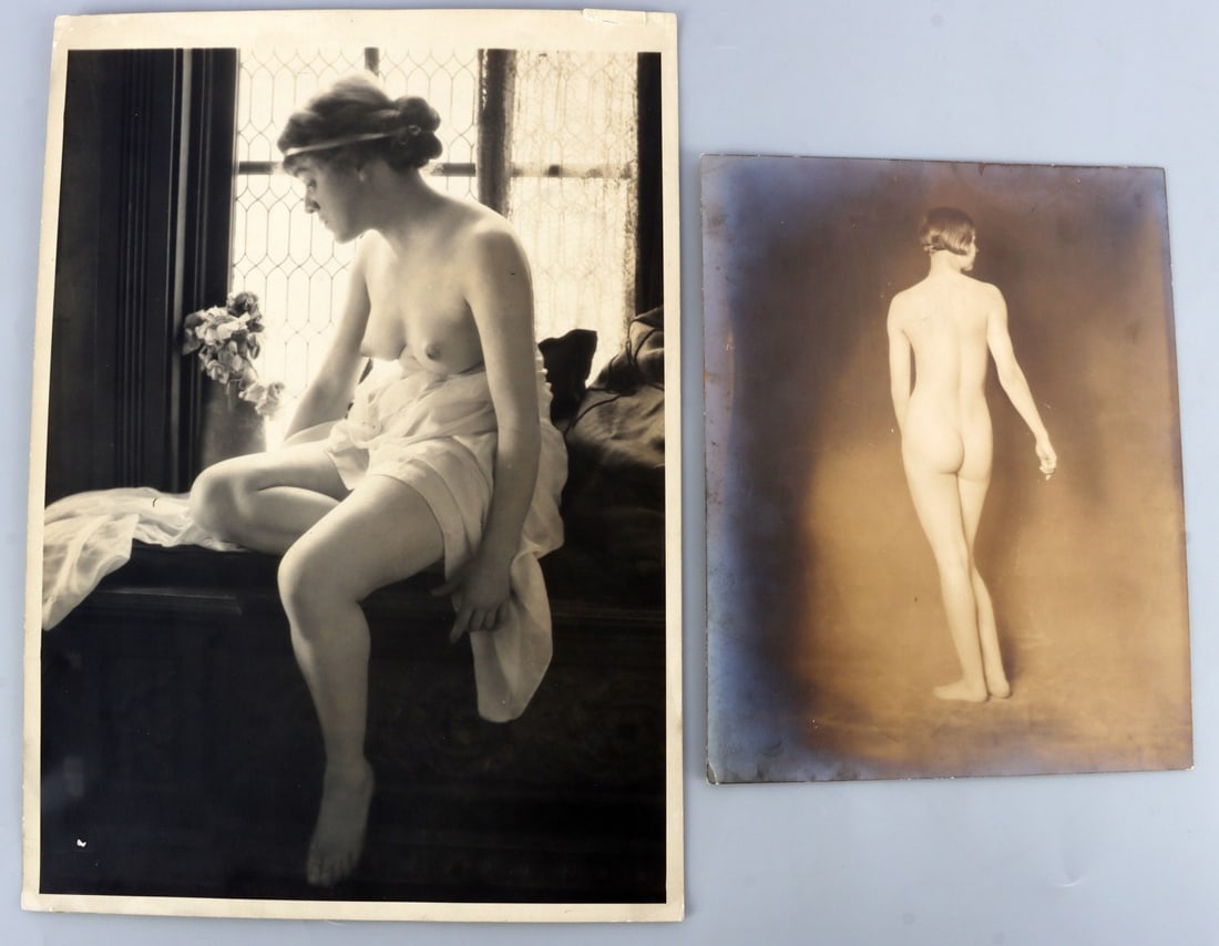 LOT OF 2 EARLY FEMALE NUDE PHOTOGRAPHS: Lot of TWO (2). 1) Topless woman, dress pulled down, looks down and away from the camera. 10 X 14 inches. 2) Woman with a bob cut looks away from the camera. 7.75 X 9.6 inches.