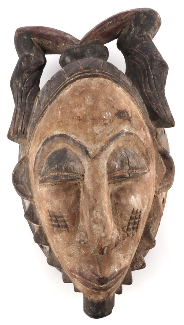 AFRICAN GABON PUNU OKUYI WHITE DANCING MASK: Okuyi society ritual dancing mask from Gabon. Mask possesses arching features and dash markings along the cheeks meant to represent archetypal youth and beauty. The white color of the mask is indicati