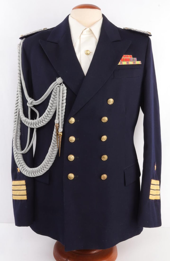 GERMAN DEMOCRATIC REPUBLIC CAPTAINS JACKET: Frigate captain's uniform from the German Democratic Republic (East Germany). Blue fabric jacket and white fabric shirt with silver bullion shoulder tabs and copper buttons. Gold brocade on sleeves. S