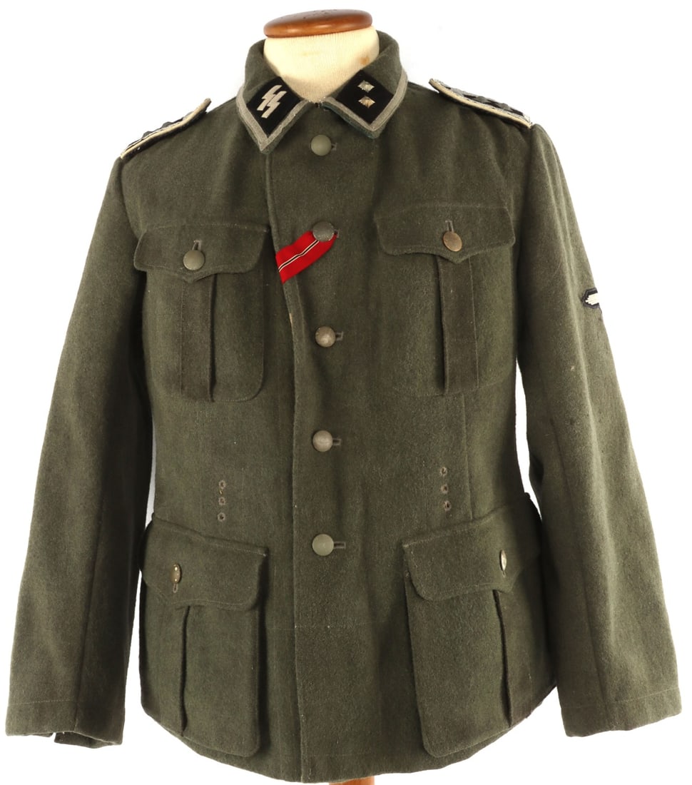 WWII LATVIAN WAFFEN SS M40 FIELD TUNIC: Field gray tunic with collar tabs, shoulder boards, Latvian patch, and Reichsadler. Interior ink stamped with "41/70 98 44/61". Pebbled buttons. Very good condition. Some fluorescing on shoulder board