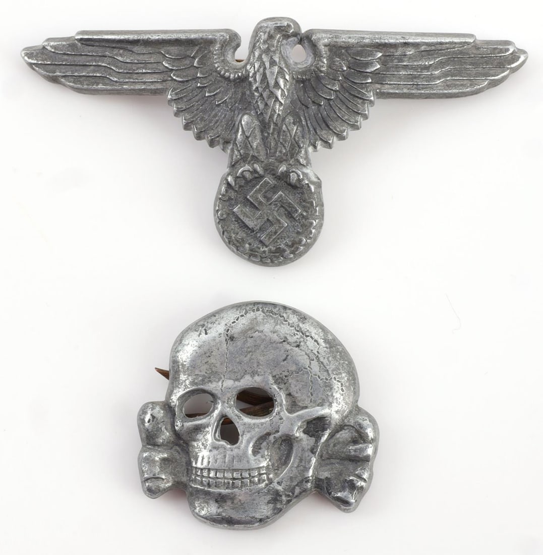 WWII GERMAN SS VISOR CAP INSIGNIA SET RZM 475/42: Lot of TWO (2) pieces. Waffen SS peaked visor cap zinc insignia set. Both marked "SS 475/42 RZM" on reverse. Good condition. One prong has detached from the skull insignia. Unauthenticated, sold "as i