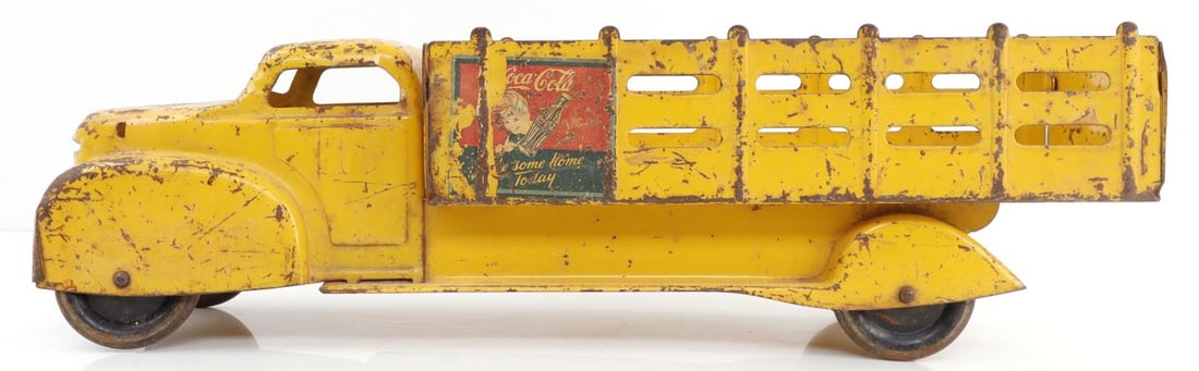 PRESSED STEEL COCA COLA SPRITE BOY TRUCK TOY: This pressed steel toy truck from Marx is an advertising piece for Coca-Cola and has Sprite Boy signage painted on it. Paint is scratched over entire body of item. 1940s. Steel bar under chassis where
