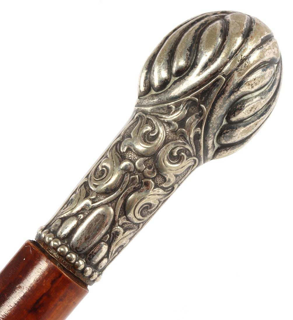 19TH CENTURY BRITISH MALACCA & SILVER CANE: Silver knobbed cane on Malacca wood. Floral pattern on knob. Brass ring on the Malacca wood. British, 19th century. 34.6 inches. Very good, original condition. This lot has a reserve.