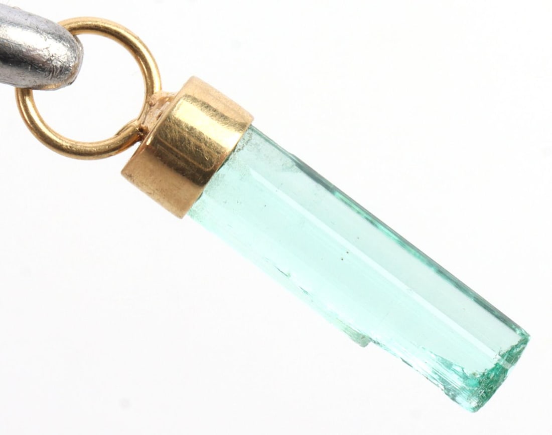 GREEN COLOMBIAN EMERALD AND 18K GOLD PENDANT: Vibrant green emerald set in 18K gold. Gold tested. Approximately .4 inches in length. Includes white box. Very good, "like new" condition. This lot has a reserve.