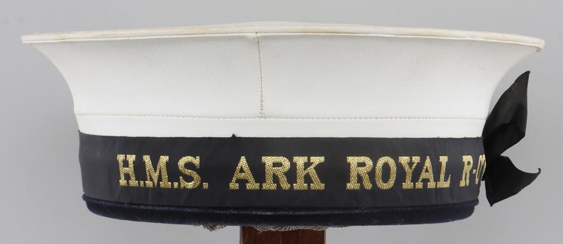 WWII BRITISH ROYAL NAVY WHITE DUCK RATING CAP: WWII British Royal Navy white duck rating cap for the HMS Ark Royal R-07. Junior class cap. White canvas construction with black cotton band. 7.5-inch diameter. Slight fluorescing. Very good condition