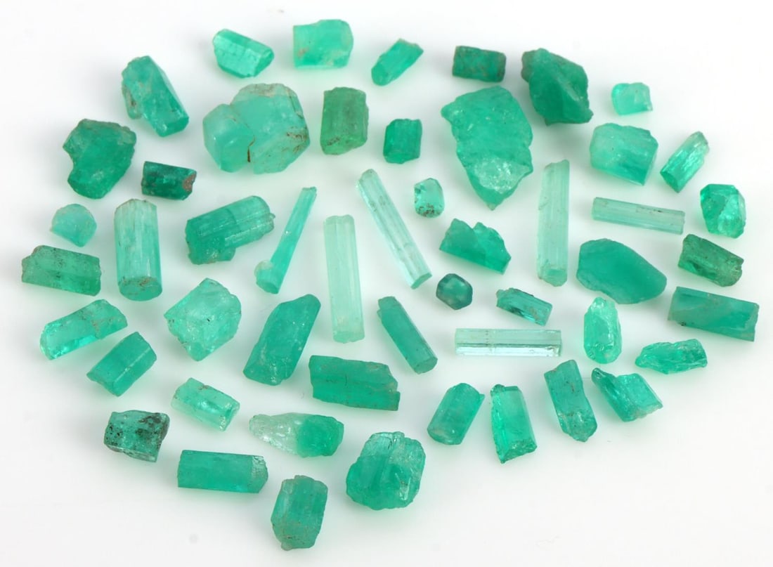 24 CARATS OF UNCUT COLOMBIAN EMERALDS: 24 carats of uncut Colombian emeralds. Sizes vary. Color ranges from very light to light. Some visible inclusions, some are eye clear. Uncut. In very good, "like new" condition. This lot has a reserve