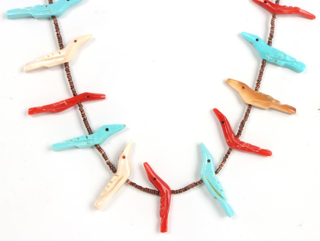 NATIVE ZUNI ANIMAL FETISH NECKLACE BY WAATS: Zuni animal fetish necklace featuring carved birds. Silver cones and clasp, stamped. 27 birds made of turquoise, coral, or serpentine. 34 inches. Very good, original condition. Attributed to Bryant Wa