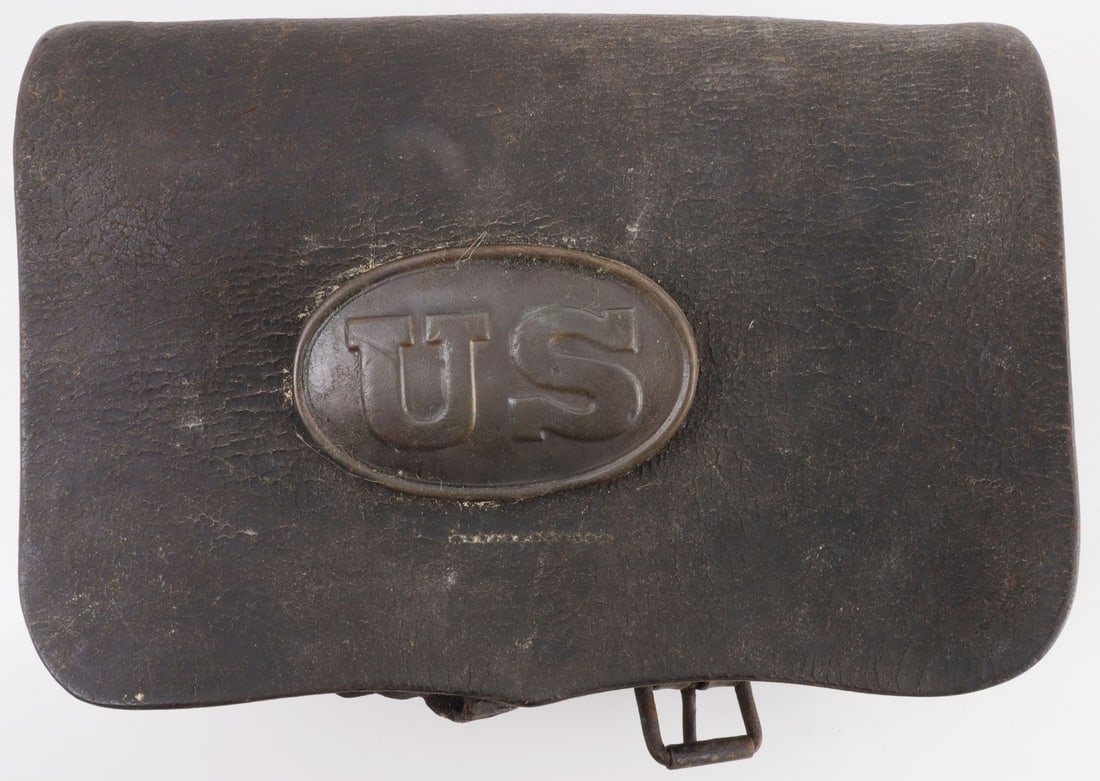 US CIVIL WAR MODEL 1861 LEATHER CARTRIDGE BOX: Model 1861 leather cartridge box from the American Civil War. US stamped brass plate on front. Double layering of flaps leading to two interior pouches, each with a metallic insert to maintain shape a