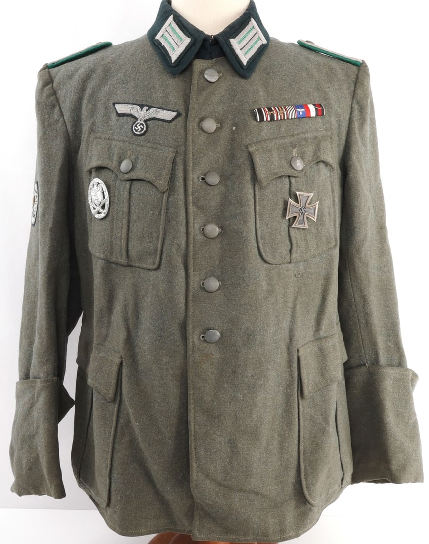 WWII GERMAN ARMY FOREST TROOPER TUNIC: Tunic features collar tabs, shoulder boards, Iron Cross, General Assault badge, ribbon bar, and more. Very good condition. Some fluorescence on patches. Likely post- war.