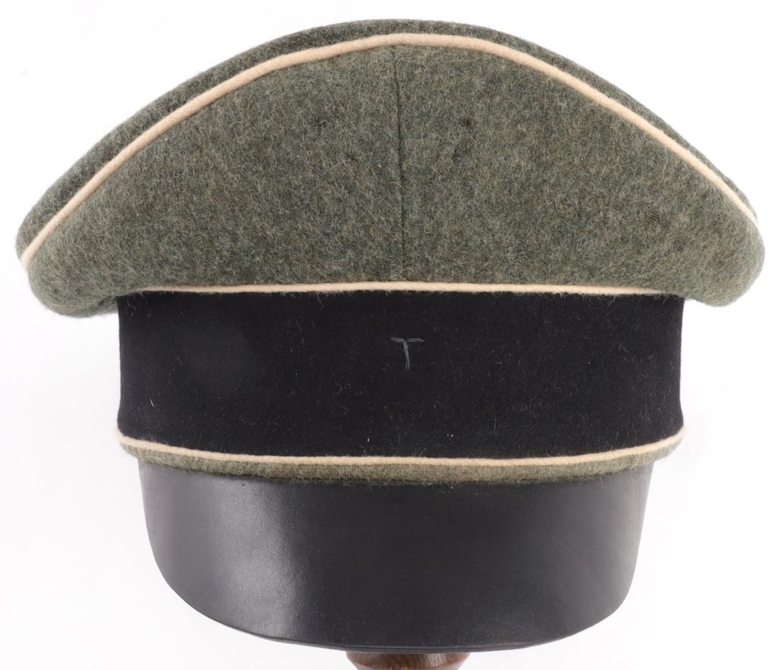 WWII GERMAN SS OFFICER CRUSHER VISOR CAP BY MULLER: Third Reich Waffen-SS officer's crusher peaked visor cap. Exterior of feldgrau wool with back doeskin band, white piping and black leather visor. The peak of the cap shows pinholes left by insignia. J