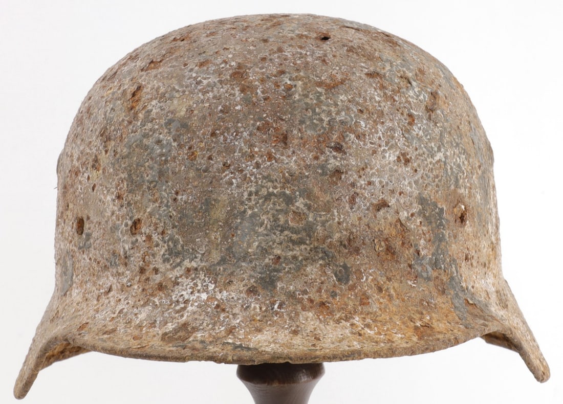WWII GERMAN M35 STAHLHELM BATTLEFIELD RELIC: Decal remnant visible on left side of helmet. Relic condition with heavy oxidation.