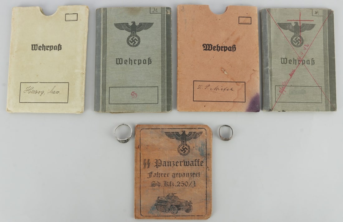 LOT OF 5 WWII GERMAN SA RINGS AND BOOKLETS: Lot of FIVE (5) rings. Size 13 and 8, SA ring shank is split. Booklets are for workers and one SS panzer division. Unauthenticated, sold "as is."