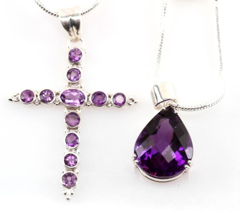 12.75 CTW & 84.20 CT NATURAL AMETHYST PENDANTS: Pendants are mounted in .925 sterling silver. One pendant has 12.75 ctw amethyst stones in shape of a cross, the other is 84.2 ct by itself. Includes two 20 inch 2mm chains (not silver). Size: 20 Weig