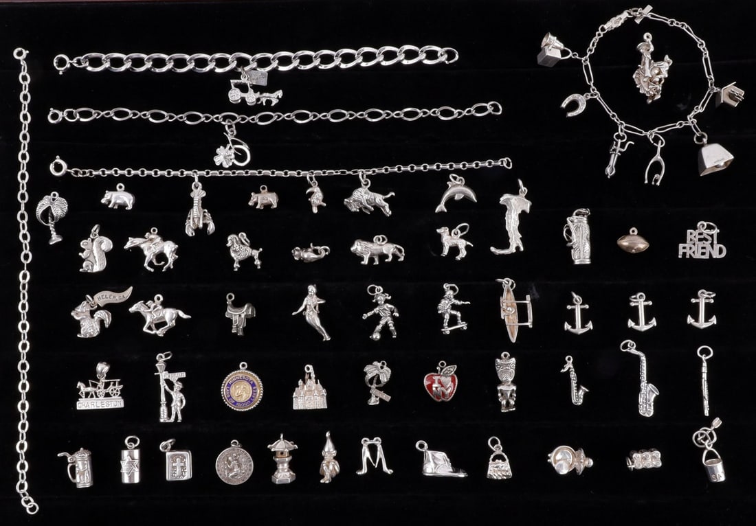 OVER 147 GRAMS OF SILVER CHARMS & CHARM BRACELETS: 147.2 grams of silver charms and charm bracelets. Five bracelets some with charms already added. Large mix of 56 charms. This includes sports, animals, places and many more. Most are marked 925 others