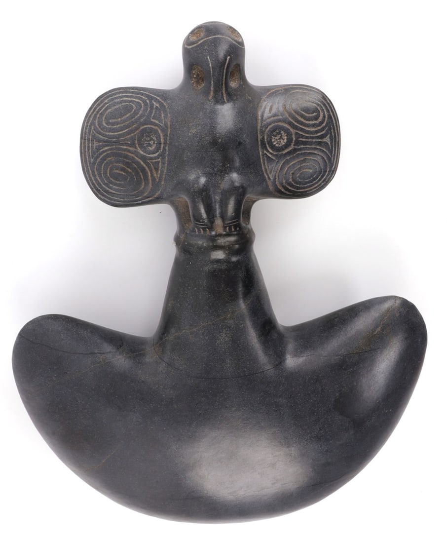 TAINO PRECOLUMBIAN CEREMONIAL BIRD AX: Taino Precolumbian pelican or duck head zemi. Highly embossed wings. On the reverse the wings join in the end to become a second abstract head. Base is concave, pecked, and polished. Magnetite constru