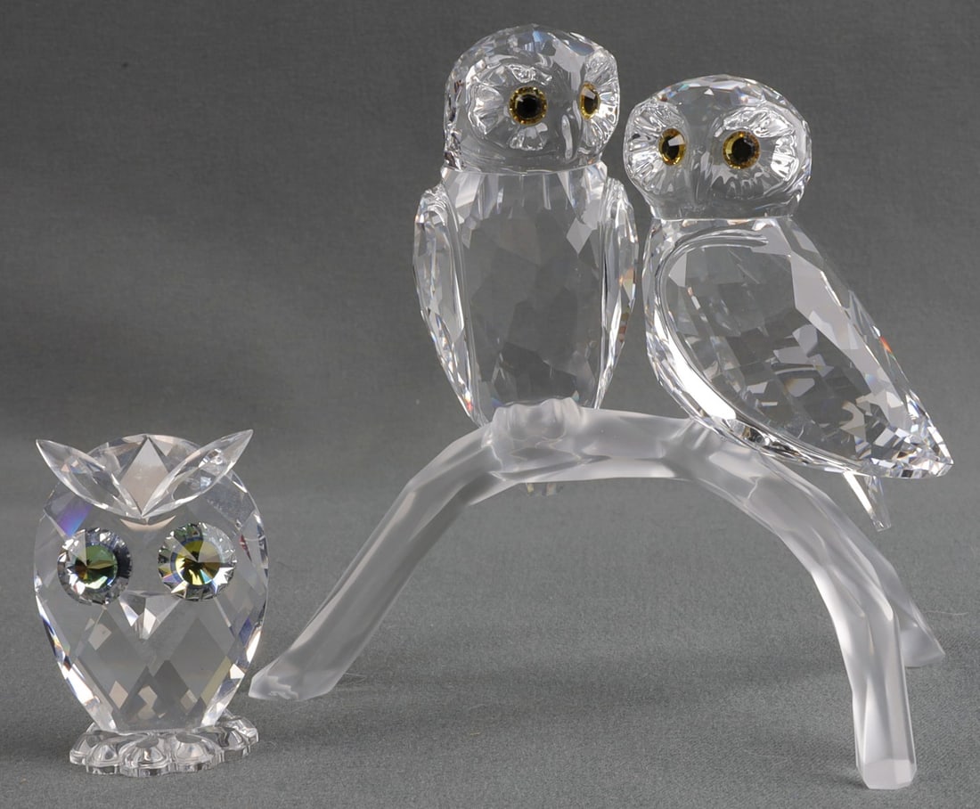 LOT OF 2 SWAROVSKI CRYSTAL OWL FIGURINES: A set of Swarovski crystal animals. 1) Two owls resting on a branch. 2) A small stand-alone owl. Both are in original packaging, though owl pair on branch are missing the lid. Very good, original cond