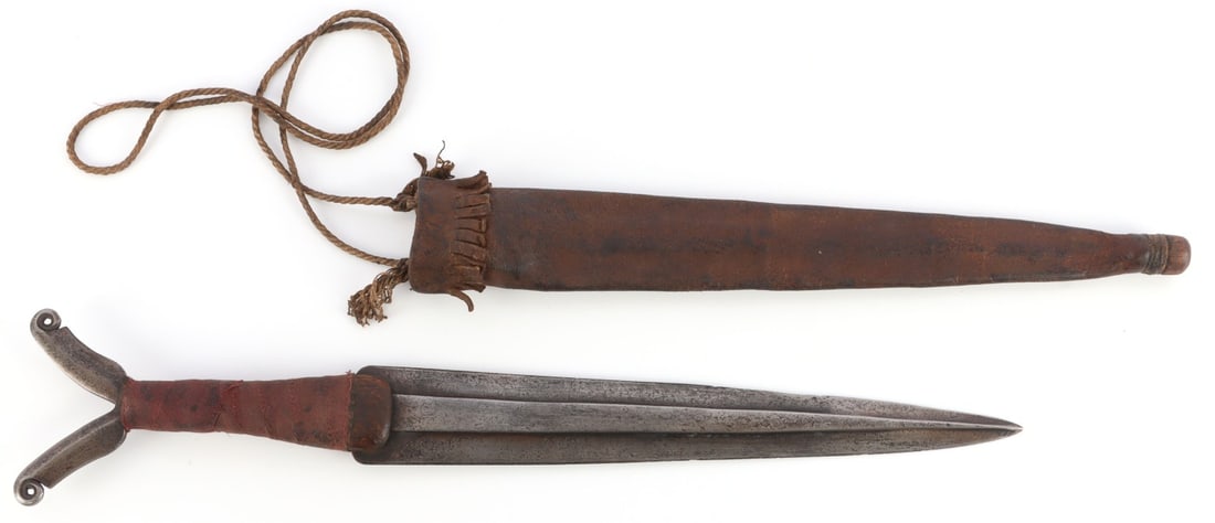 NATIVE AMERICA ATHABASKAN IRON BLADE SIDE DAGGER: A Native American Indian Athabaskan side dagger made of iron. Pommel has a flowing, feather-like design. Blade is flat on one side, and is 10.5 inches long. Leather scabbard. Late nineteenth or early