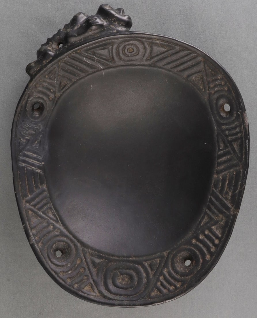 TAINO BOWL WITH THREE DIMENSIONAL FIGURE: Taino bowl with three dimensional anthropic figure on the side. The rim flange is a series of triangles, circles and slashes interspersed with 4 holes. The figure is 10 X 4 inches. Crafted from magnet
