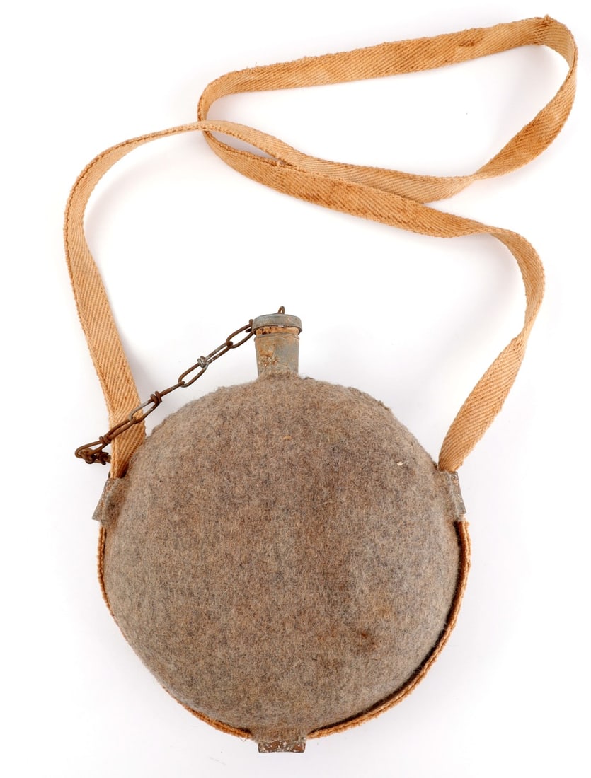 US CIVIL WAR MODEL 1858 SMOOTH SIDE CANTEEN CLOTH: Smooth side canteen with a wool cloth cover. White fabric strap remains intact. Cork plug is broken from cap but intact on hook. Some mothing present. 8-inch diameter. Very good, original condition.
