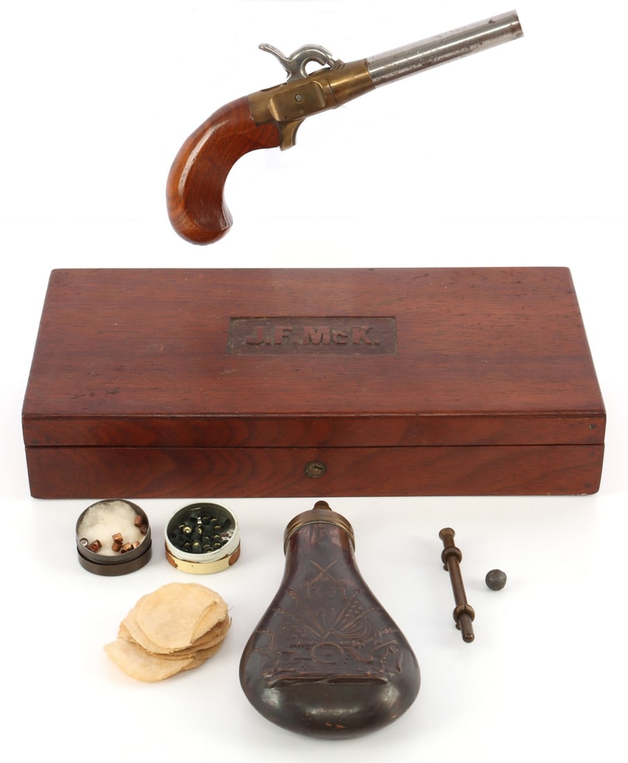 CASED .44 CMC PERCUSSION BOOT PISTOL & FLASK: CMC single-shot .44 cal percussion boot pistol with ramrod, powder flask, two tins of percussion caps and felt-lined wood case. 3 5/8-inch barrel. Underside of breech marked "CMC 7083A." Good conditio