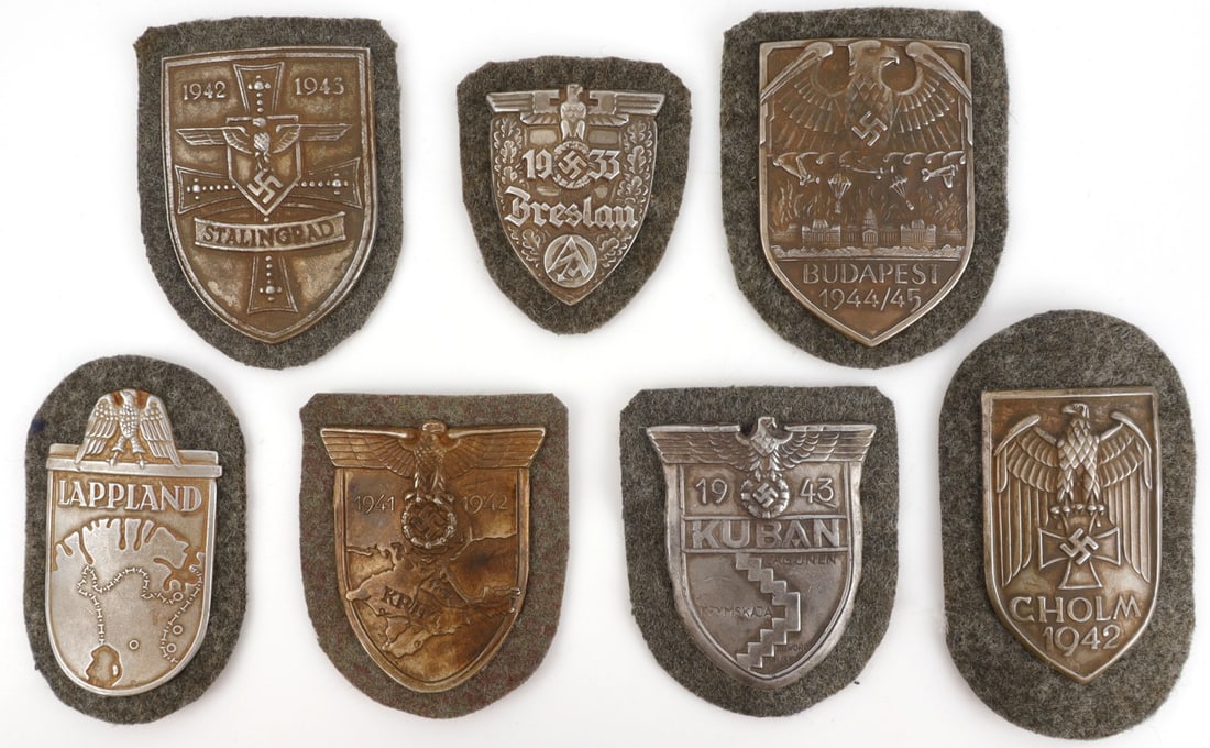 WWII GERMAN THIRD REICH CAMPAIGN SHIELDS LOT OF 7: Stalingrad, Krim, Budapest, Lappland, Scholm, Kuban, and Breslau. Unauthenticated, sold as is.